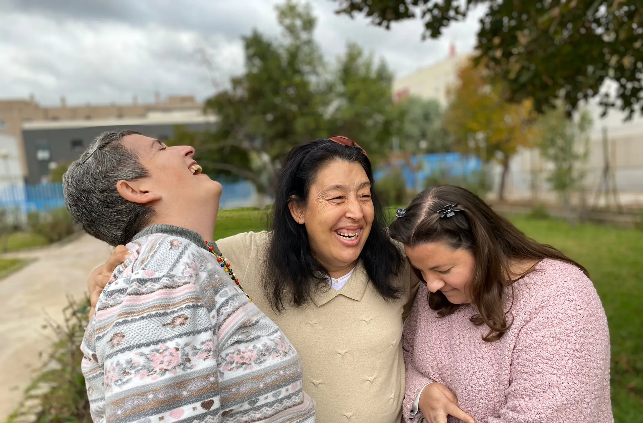 tres personas con discapacidad se abrazan y ríen