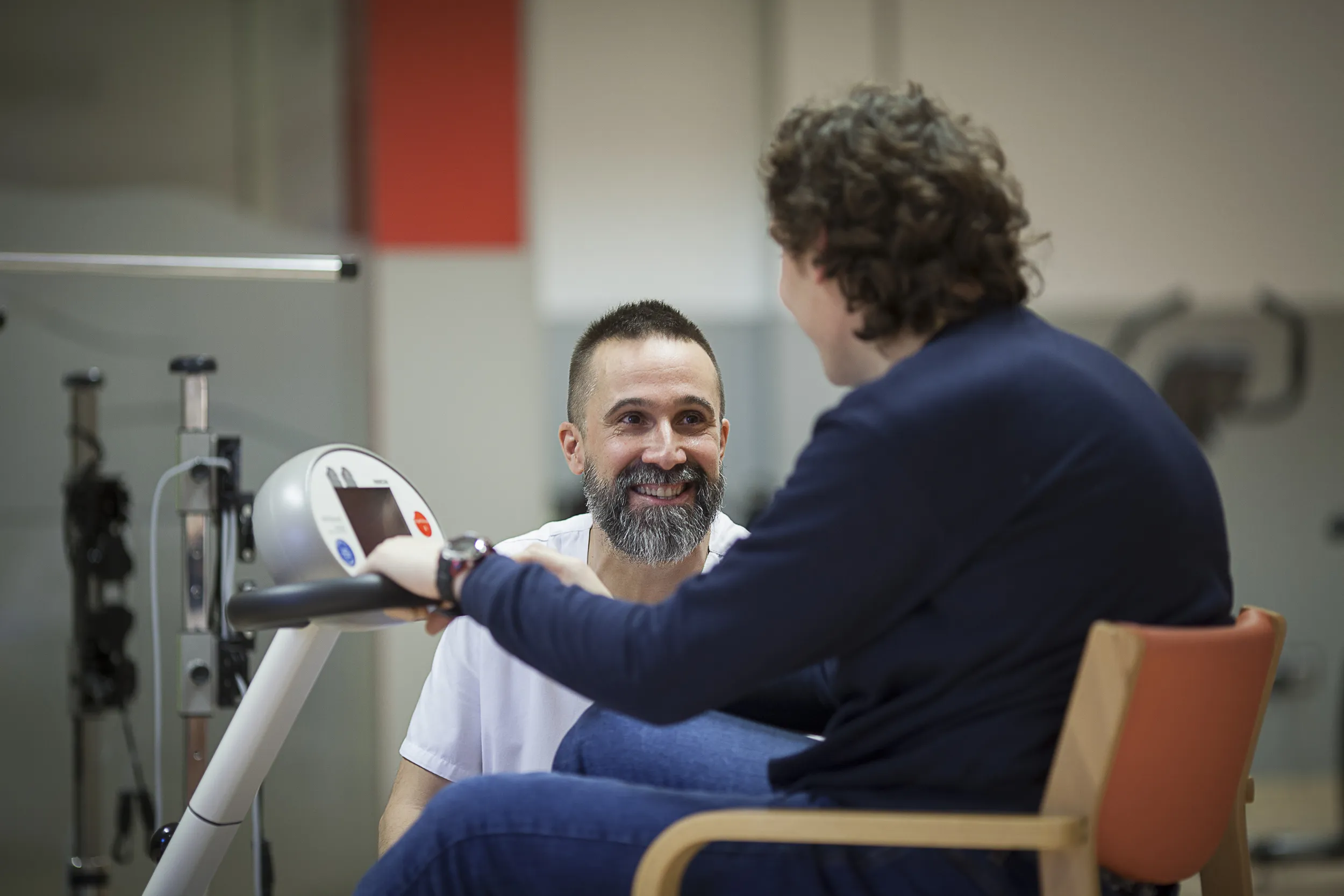un trabajador de fundacion hospitalarias junto a una persona con daño cerebral en silla de ruedas electrica